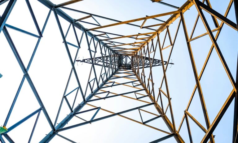 Looking up at a geometric power transmission tower in Depok, Indonesia.